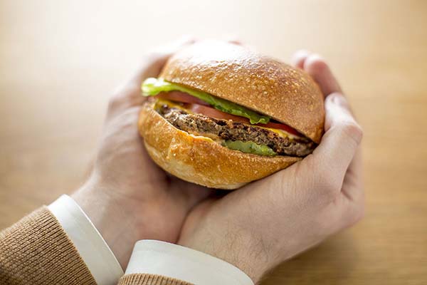 Hands lovingly holding an impossible burger at Momofuku Nishi.